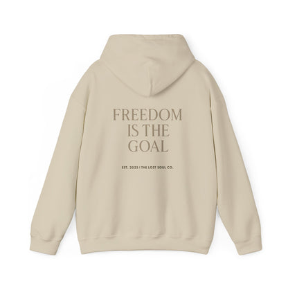 Back view of sand hoodie with serif quote “FREEDOM IS THE GOAL” center-aligned – The Lost Soul Co.
