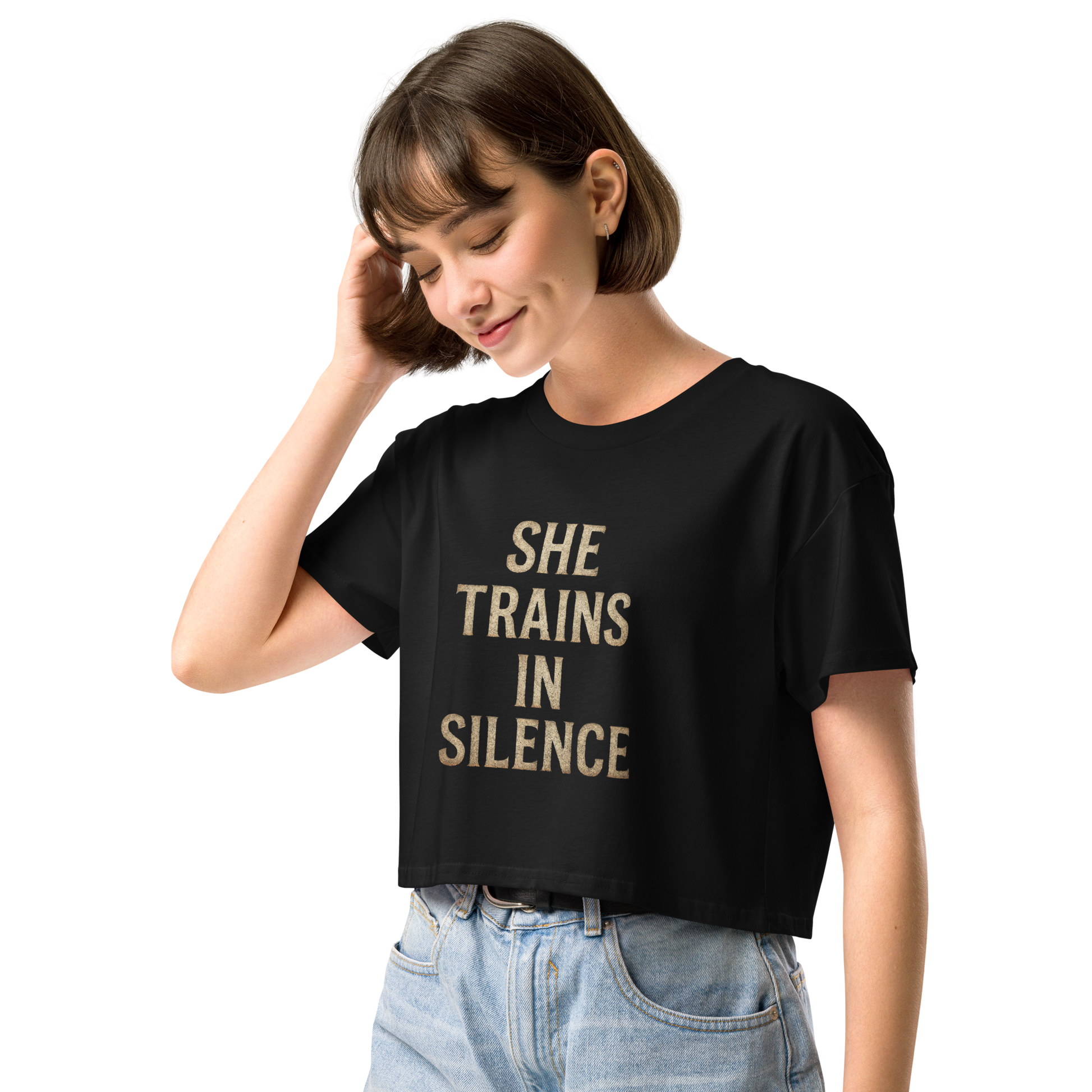 Model wearing black cropped tee with gold serif text “She Trains in Silence” – women’s relaxed fit workout crop from The Lost Soul Co.